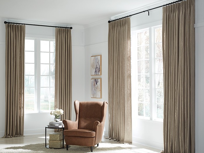 Room with white walls and brown fabric curtains. 